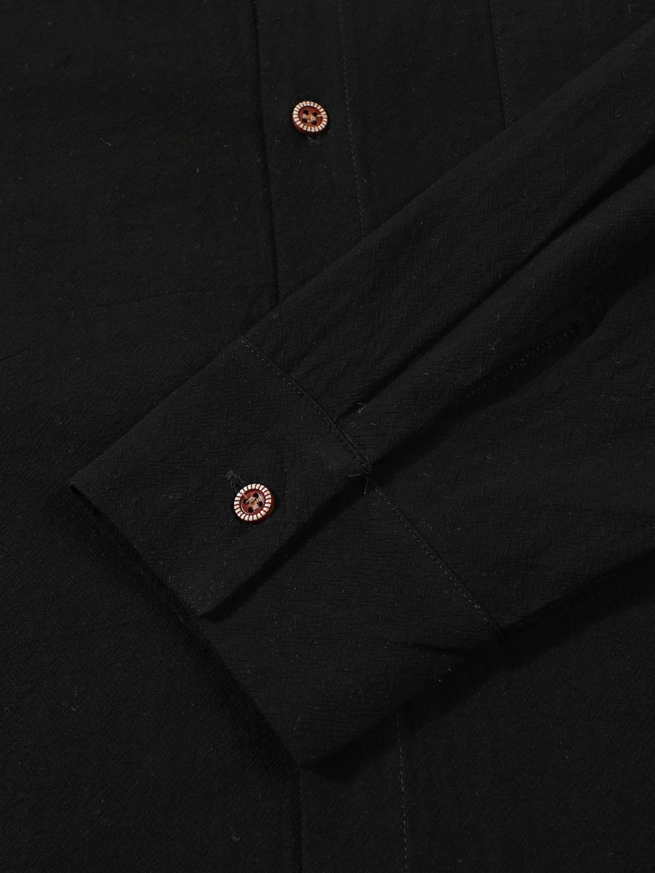 Button cuff detail on black linen shirt